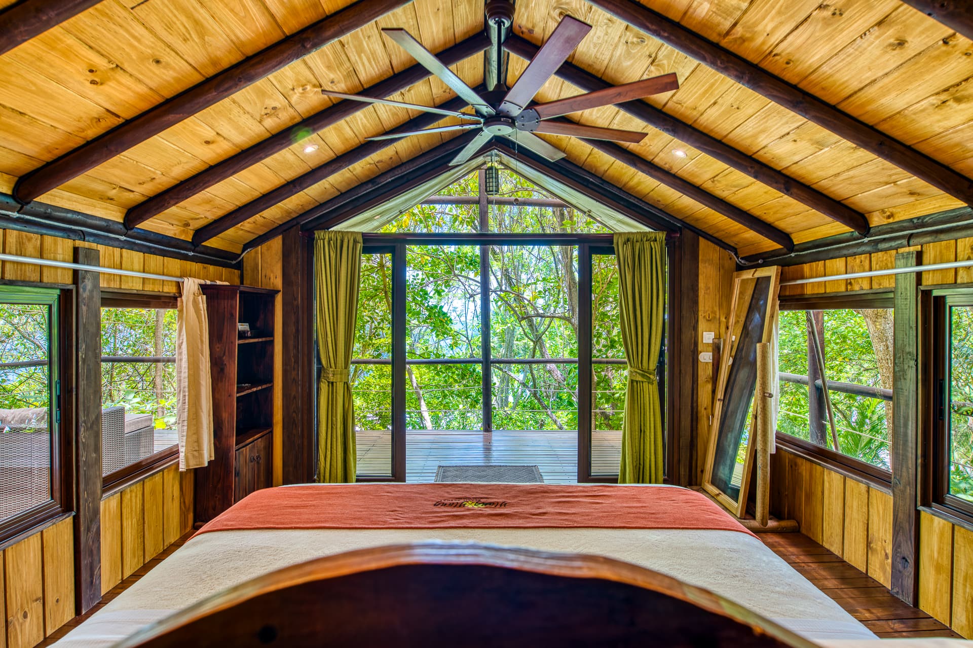 View from king bed with windows showing panoramic jungle views