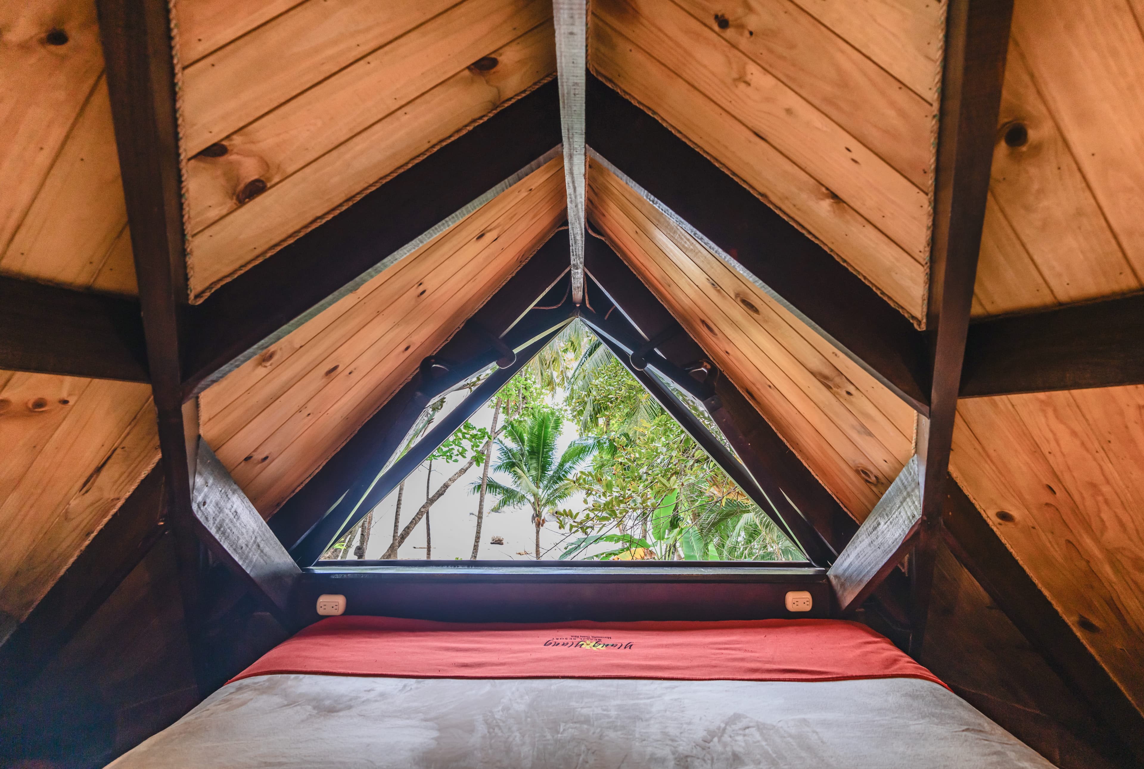 Triangular window in Coco Joes bungalow loft with a king bed