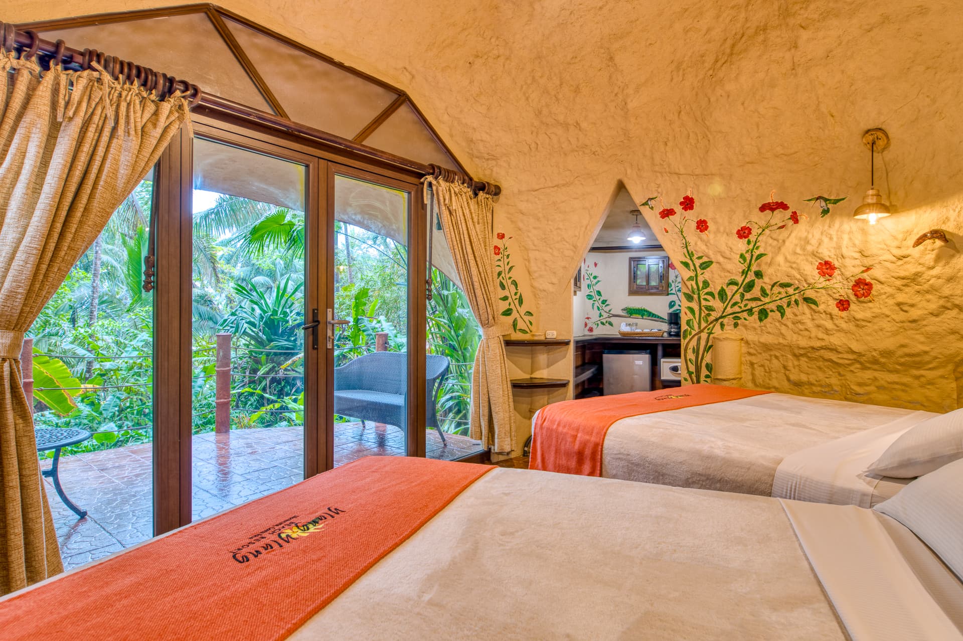 Colibri Bungalow bedroom with two queen beds and doors leading out to private patio