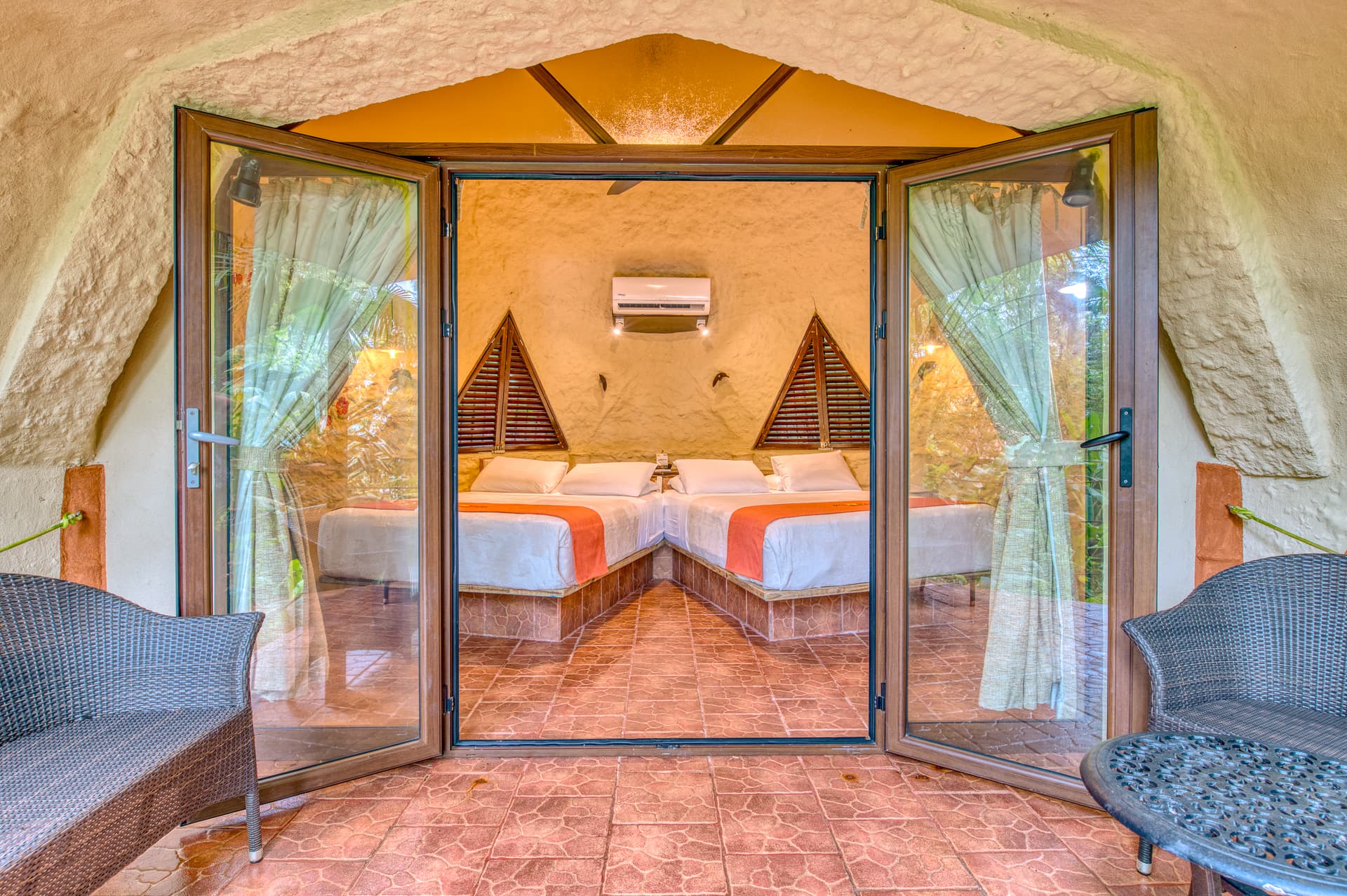 View from private patio through expansive glass doorway into bedroom