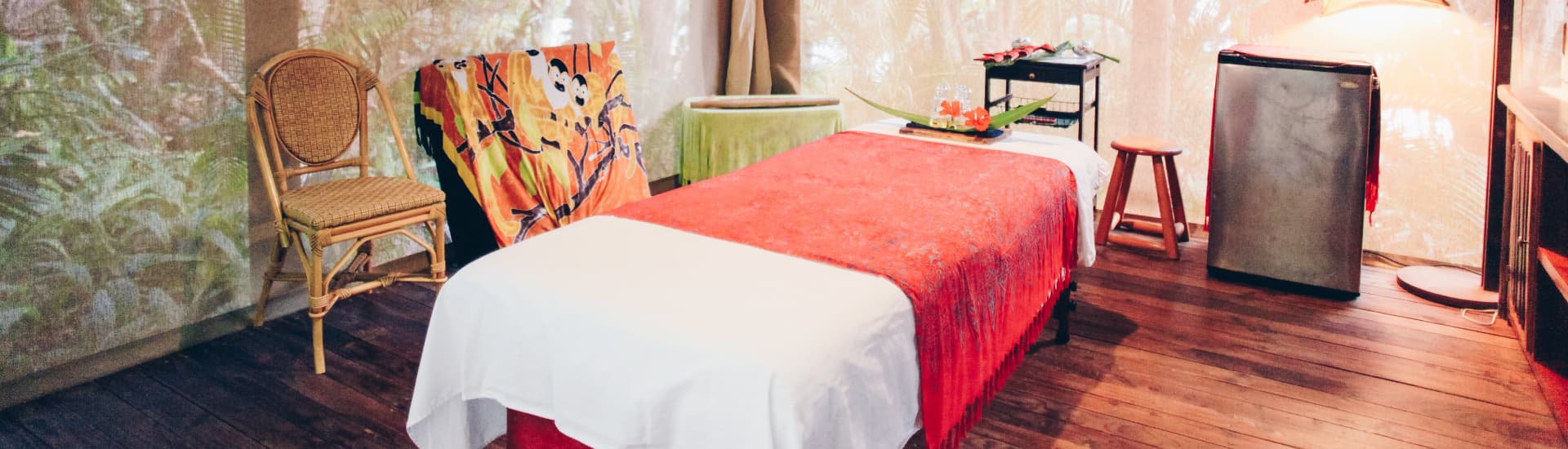 Screened-in cabana with hardwood floors and a massage table