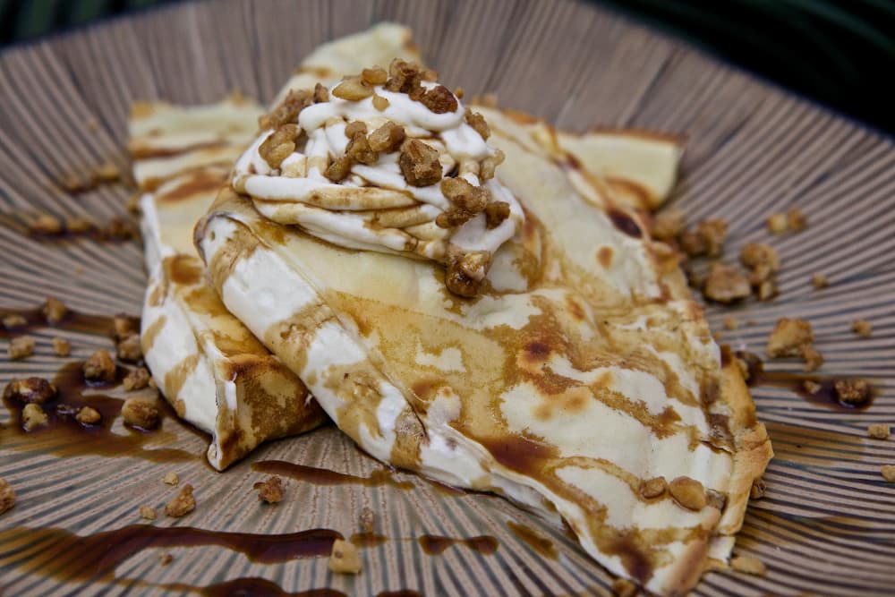desert quesadilla with sauce, cream, and nuts.