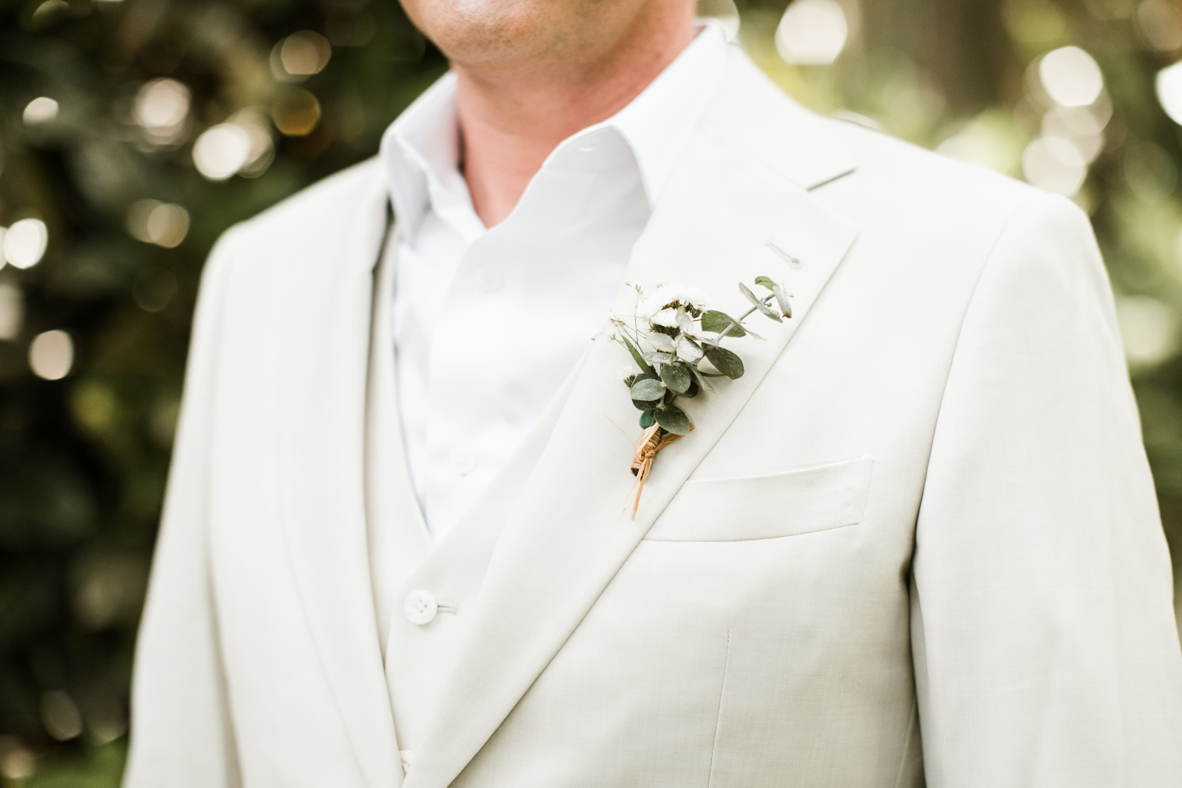 Groom in white tux with boutonniere.