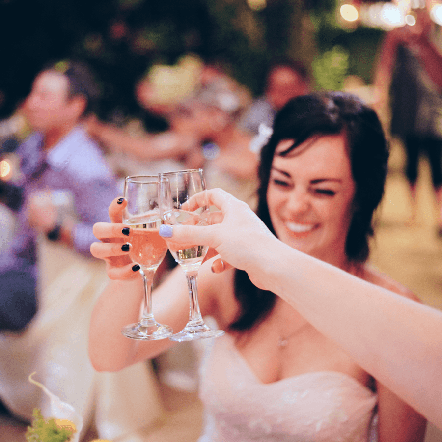 Bride celebrating with champagne flutes with others