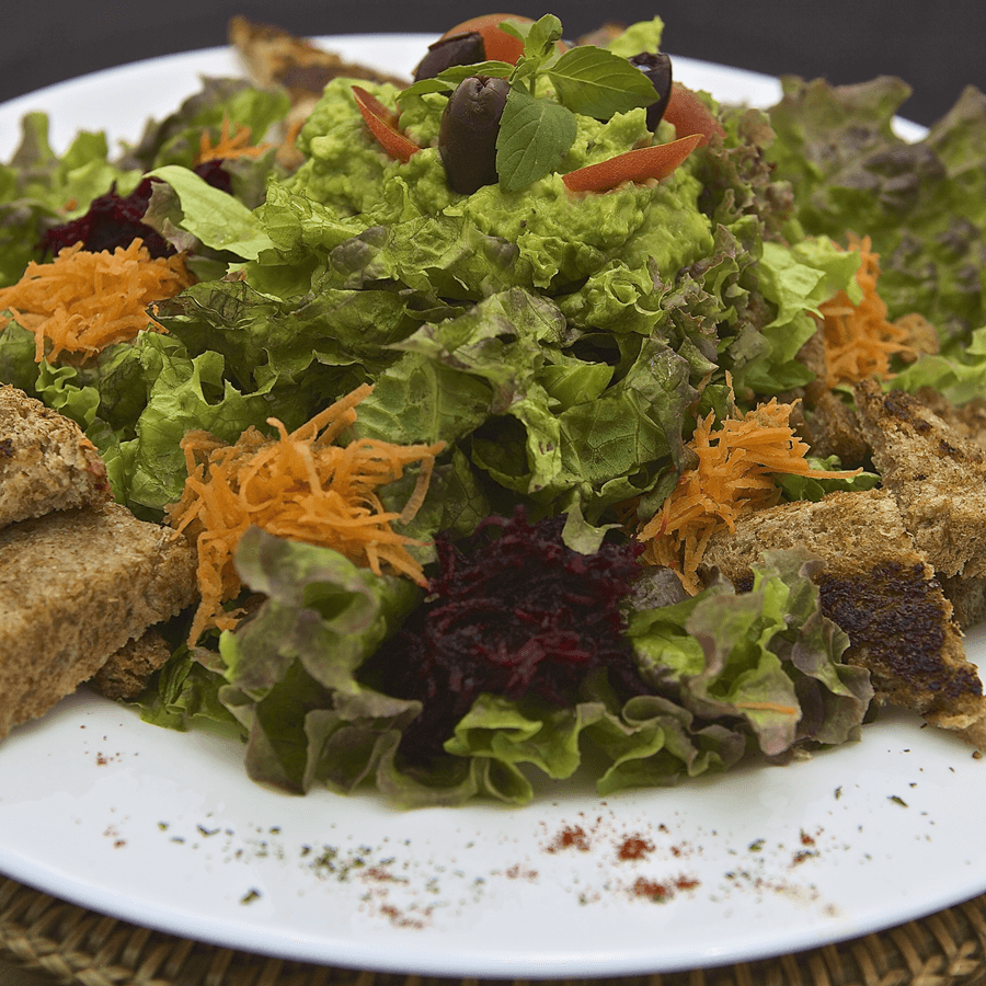 Plated salad with various greens and shredded carrots