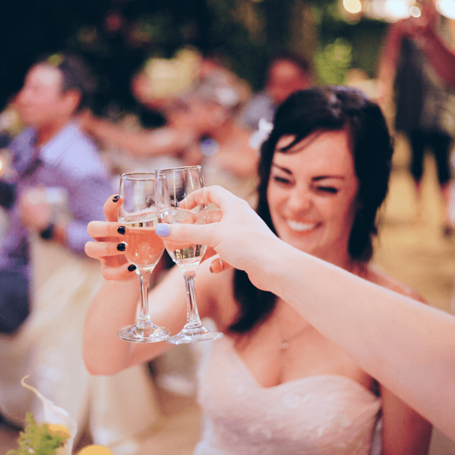 Bride celebrating with champagne flutes with others