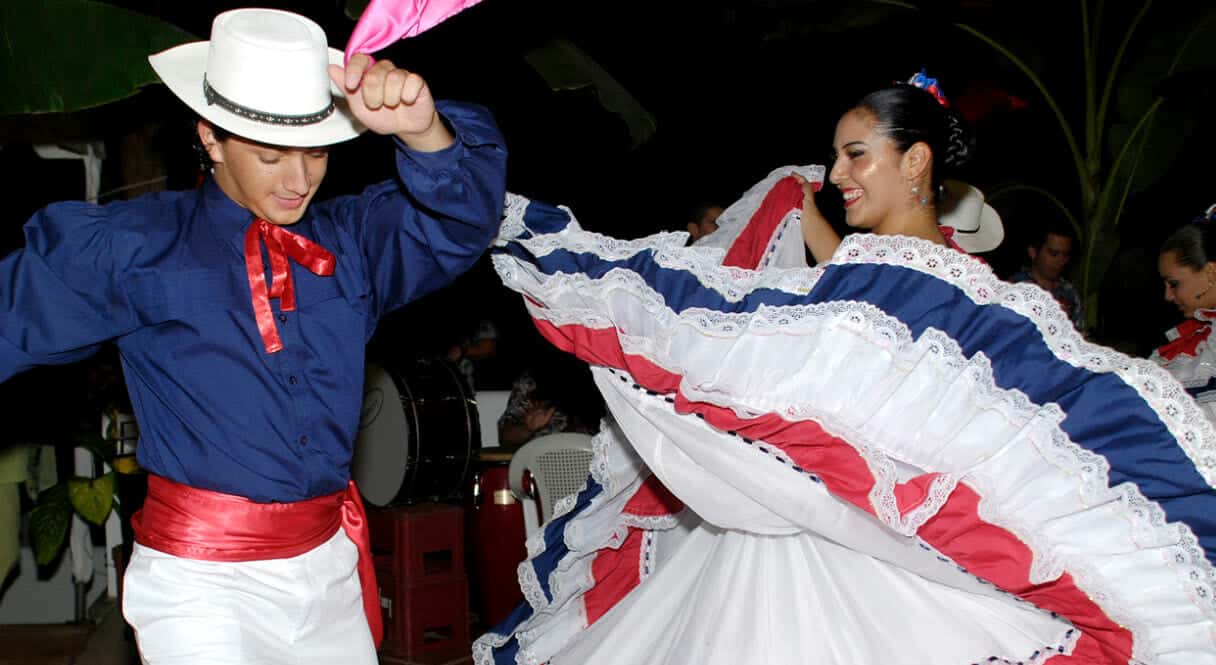 A couple dances gracefully in traditional outfits, showcasing vibrant colors and movement. A couple dances gracefully in traditional outfits, showcasing vibrant colors and movement.