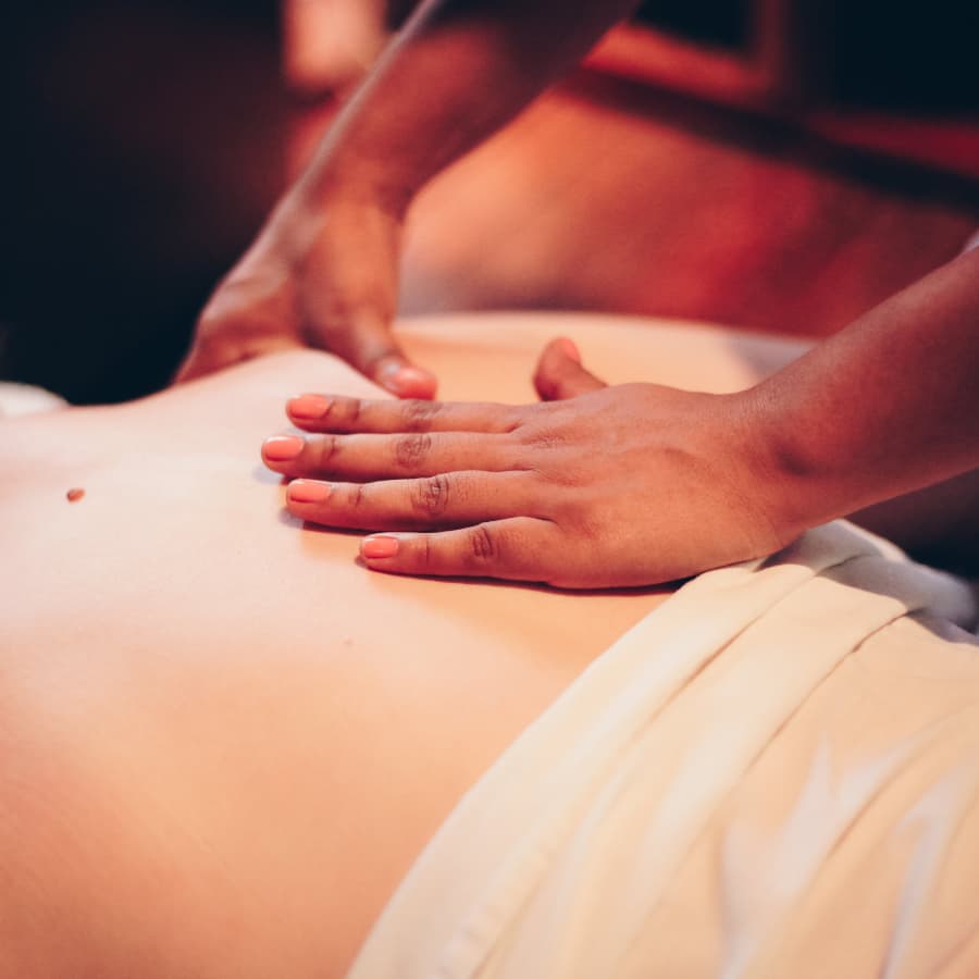Close up of a masseuse's hands massaging a person's shoulder