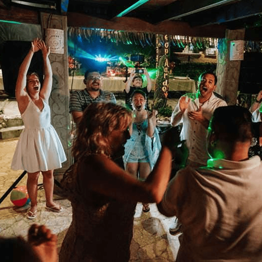 Men and women on dance floor having fun, laughing and dancing with disco lights.