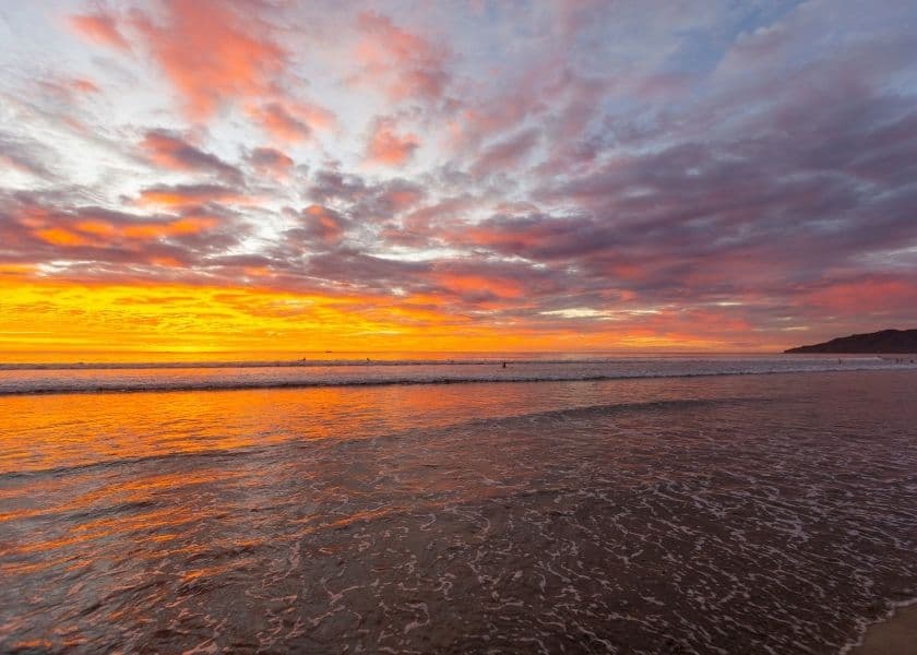 A vibrant sunset casts orange and pink hues over a calm ocean. A vibrant sunset casts orange and pink hues over a calm ocean.