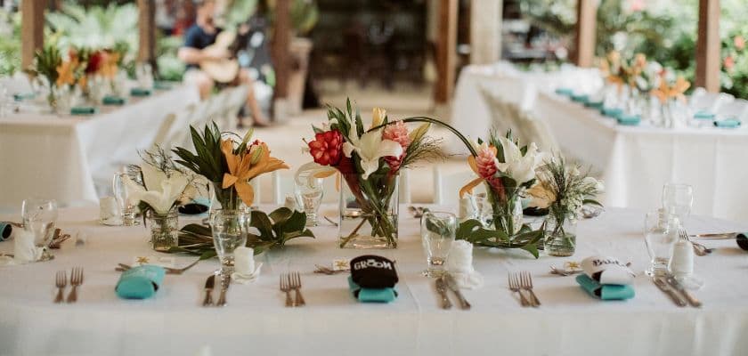 Elegant dining setup with floral centerpieces and turquoise napkin accents.
