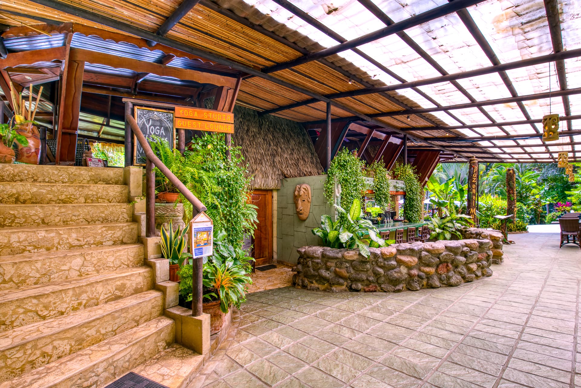 Exterior of outdoor restaurant, with rock walls and steps leading up to dining area